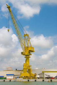 Cranes at construction site against sky