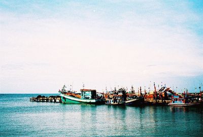 Boats moored in sea against clear sky