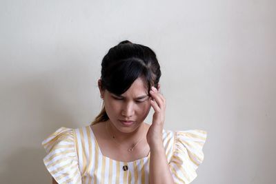 Portrait of young woman against white background