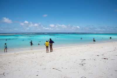 People at beach against sky