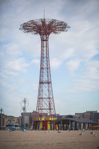 Low angle view of ferris wheel and buildings against sky