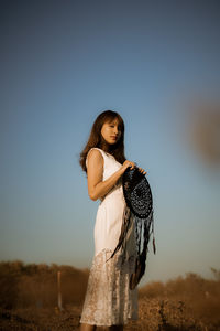 Young woman standing against clear sky