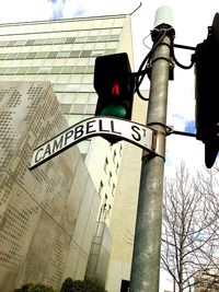 Low angle view of road signal against buildings in city