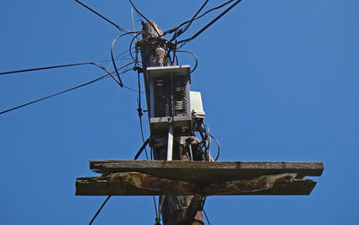 Mess on telecommunication wires on old wooden pylon