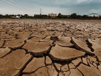 Surface level of barren land against sky