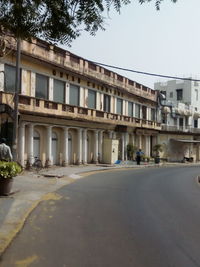 Road by building against clear sky