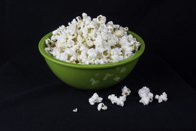 Close-up of white flowers in bowl against black background