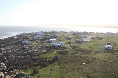 High angle view of houses by sea against clear sky