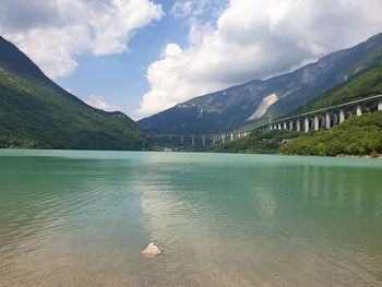 Scenic view of lake by mountains against sky