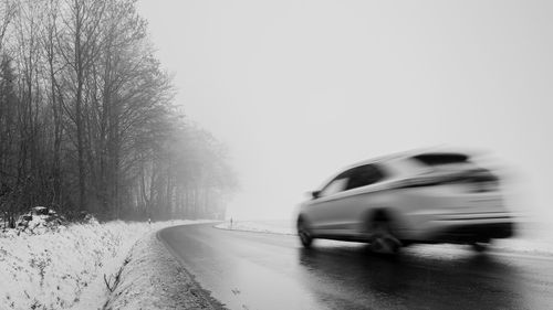 Blurred motion of car on road during winter