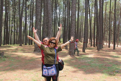 Full length of young woman standing in forest