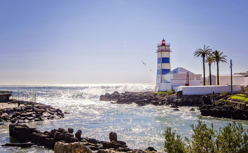 Lighthouse on shore against clear sky