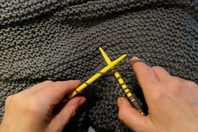 Close-up of cropped woman hands knitting wool