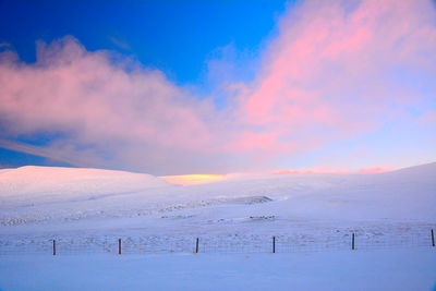 Scenic view of snow covered field against sky