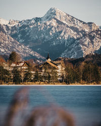 Scenic view of lake by buildings against mountains