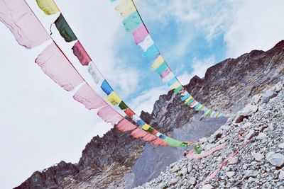 Low angle view of flags on mountain against sky