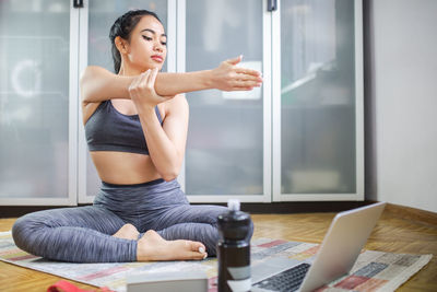Full length of woman sitting at home