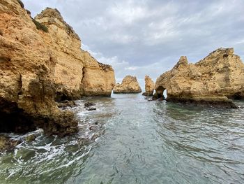 Rock formations by sea against sky