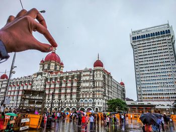 Group of people against buildings in city