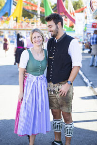 Man embracing woman while standing on street at event