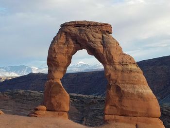 View of rock formation against cloudy sky