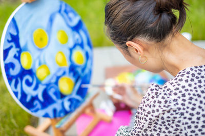 Woman painting while sitting outdoors