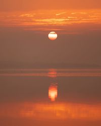 Scenic view of sea against orange sky