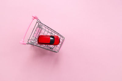 High angle view of red umbrella against pink background