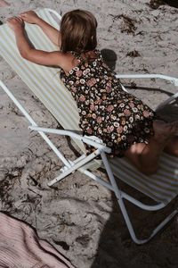 High angle view of woman sitting on chair at beach
