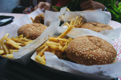 Close-up of burgers with french fries on table