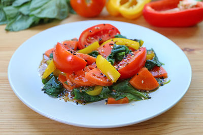 Plate of delectable colorful salad with fresh ingredients in the backdrop