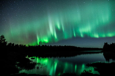 Scenic view of lake against sky at night