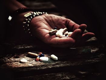 Cropped hand of woman holding pills outdoors