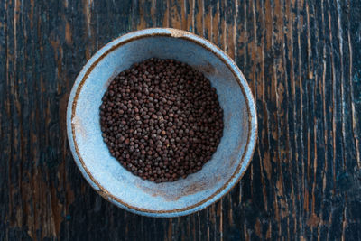 Directly above shot of mustard seeds in bowl on table