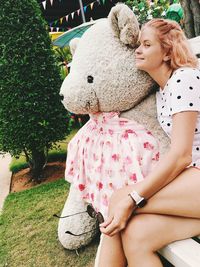 Low angle view of girl holding big bear toy