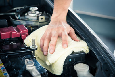 Hand cleaning car engine with a rag,worker
