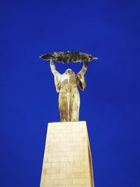 Low angle view of statue against clear blue sky