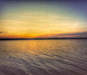 Scenic view of sea against dramatic sky during sunset