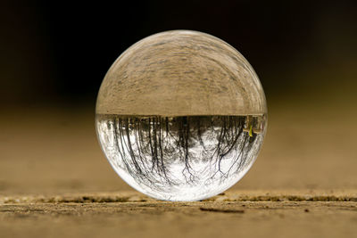 Close-up of crystal ball on land against sky at night