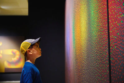 Side view of young man looking to artistic paint 