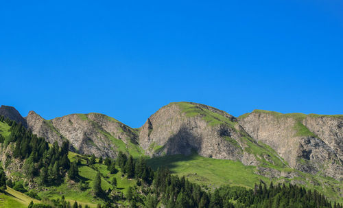 Scenic view of mountains against clear blue sky