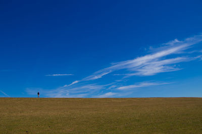 Scenic view of field against blue sky