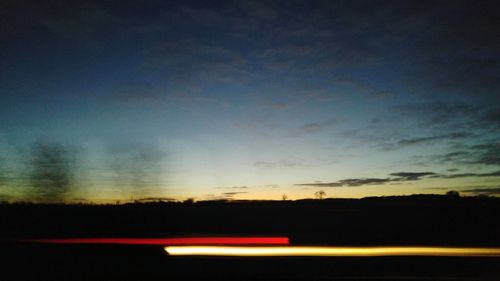Silhouette road against sky during sunset