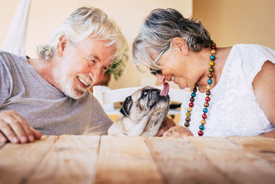 Couple playing with pug at home