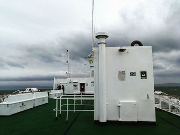 Information sign by sea against sky