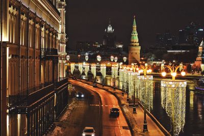 View of city street and illuminated buildings at night