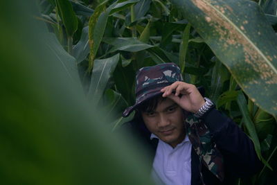 Man looking away by plants