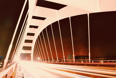 Illuminated bridge against sky at night