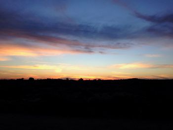 Scenic view of silhouette landscape against sky at sunset