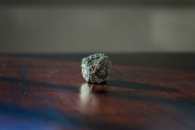 Pyrite crystal on a dark wooden table in the sunlight